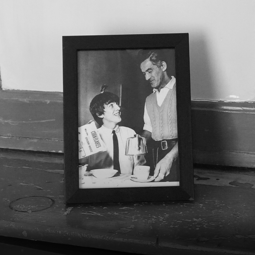a black and white photo of a framed picture of george and harold harrison